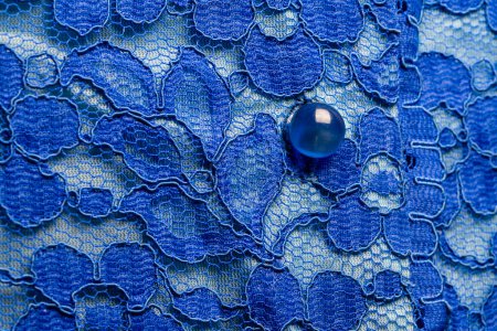 Foto de Detalle de una blusa de mujer azul hecha de tela guipur con botones de nácar, primer plano - Imagen libre de derechos