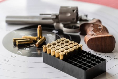 Photo for Revolver gun and bullets on background of the target, close up - Royalty Free Image
