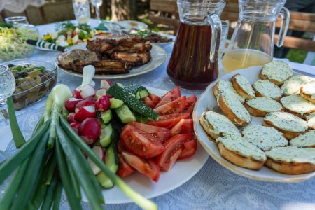 Téléchargez les photos : Table complète de repas ukrainiens sur la table pour manger. Table avec de nombreux repas préparés et de la nourriture dans le jardin d'été, à l'extérieur, fermer - en image libre de droit