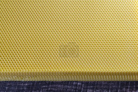 Téléchargez les photos : Texture de fond et motif de la section voshchina de nid d'abeille en cire d'abeille pour rempli de miel. Voshchina une base artificielle pour la construction de nids d'abeilles, feuille de cire des cellules - en image libre de droit