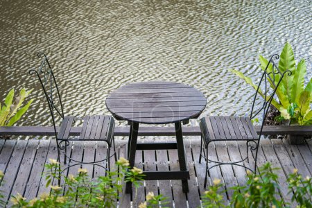 Téléchargez les photos : Chaises et table sur la cour arrière dans le jardin tropical près du lac avec belle vue sur l'île de Bornéo, Malaisie, gros plan - en image libre de droit