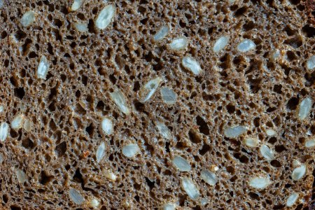 Téléchargez les photos : Fond ou texture abstrait pain noir fait maison avec graines de tournesol, gros plan, vue sur le dessus, macro - en image libre de droit