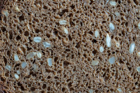 Foto de Fondo abstracto o textura pan negro casero con semillas de girasol, primer plano, vista superior, macro - Imagen libre de derechos