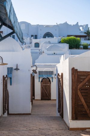Téléchargez les photos : Bâtiments muraux blancs dans la rue par jour ensoleillé dans la ville de villégiature Sharm El Sheikh, Egypte, concept d'architecture - en image libre de droit