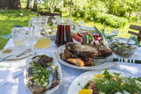 Photo for Full table of ukrainian meals on the table for eat. Table with many ready meals and food in the summer garden, outdoors, close up - Royalty Free Image