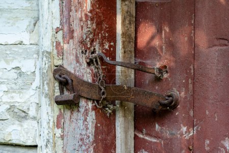 Téléchargez les photos : Cadenas très rouillé fermant une porte en bois, fermer. Une vieille porte en bois verrouillée avec un cadenas rouillé tout aussi vieux. Fond vintage - en image libre de droit