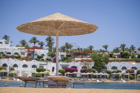 Téléchargez les photos : Parapluie de paille de plage et chaises longues près de la mer Rouge dans la station balnéaire de Sharm El Sheikh le matin, Egypte, gros plan - en image libre de droit