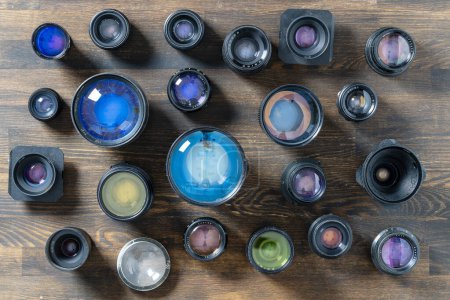 Photo for A lot of vintage camera lenses from the times of the USSR on a wooden background, close up, top view - Royalty Free Image