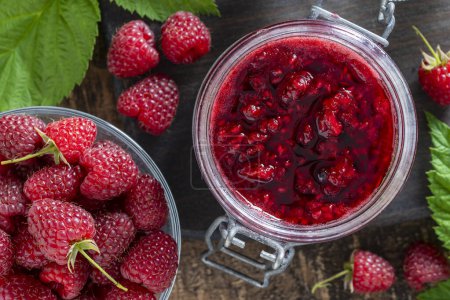 Photo for Red raspberry jam and fresh raspberry on a wooden table. Rustic style, close up, top view - Royalty Free Image