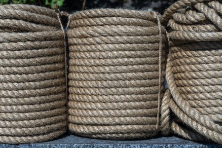 Foto de Cuerda de cáñamo de yute natural enrollado en una bobina, de cerca. Carrete marrón de textura de cuerda de lino en el fondo - Imagen libre de derechos