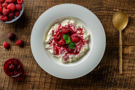 Téléchargez les photos : Fromage cottage blanc frais avec crème sure et confiture de framboise rouge sur fond bois, gros plan, vue sur le dessus - en image libre de droit