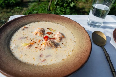 Téléchargez les photos : Soupe de saumon à la crème, pommes de terre, carottes, poivrons et herbes dans un bol sur la table, gros plan - en image libre de droit