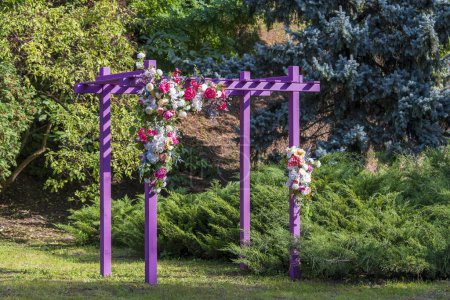 Photo for Front view of a decorative pink pergola with artificial flowers in urban garden, close up - Royalty Free Image