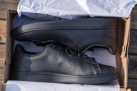 Téléchargez les photos : Kiev, Ukraine - octobre 05, 2023 : Magnifiques chaussures neuves Adidas full black en boîte, gros plan, vue sur le dessus - en image libre de droit
