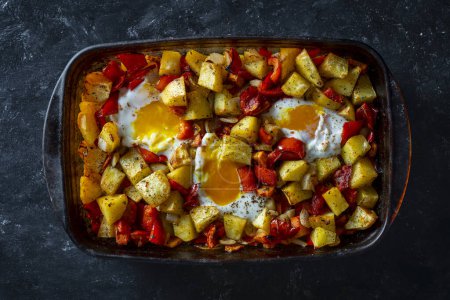 Téléchargez les photos : Mélanger les légumes cuits au four avec les œufs dans un plat en verre pour la cuisson, fermer, vue sur le dessus - en image libre de droit