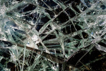Cracks from a bullet shot in armored glass in combat vehicle. Armor piercing glass of damaged military fighting vehicle during war between russia and Ukraine. Texture bulletproof glass after an attack