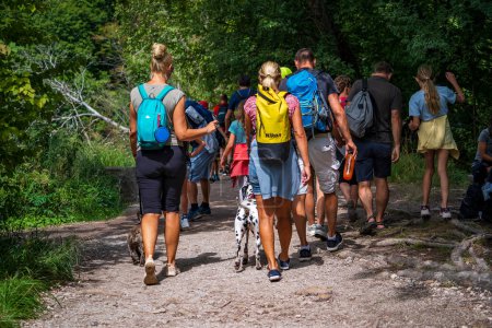 Foto de Plitvice Lakes, Croacia - 30 de agosto de 2021: Grupo de personas caminando por el camino de tierra del lago Plitvice, cerca del verde bosque salvaje, Croacia, Europa Central, viaje y concepto de naturaleza - Imagen libre de derechos