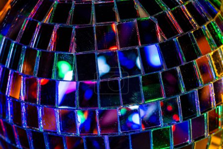 Téléchargez les photos : Lumineux miroir brillant boule disco réfléchissant la lumière dans une pièce sombre, fermer. Concept de vacances - en image libre de droit