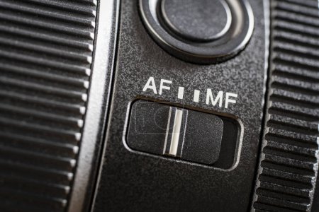 Foto de Primer plano del botón de enfoque automático o manual en la nueva lente de la cámara. Interruptor Af y mf en la lente de la cámara, controles de una cámara sin espejo, macro - Imagen libre de derechos