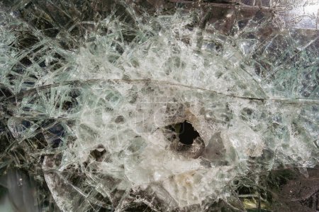 Photo for Bullet hole in armor-piercing glass. Armor piercing glass of damaged military infantry fighting vehicle during war between russia and Ukraine. Background and texture bulletproof glass after an attack - Royalty Free Image