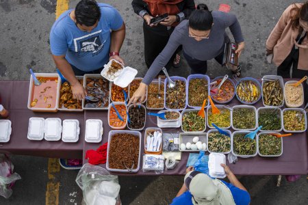 Téléchargez les photos : Kota Kinabalu, Malaisie - 24 février 2020 : Vendeur de nourriture de rue préparant la nourriture traditionnelle malaisienne pour les gens dans le marché de nuit à Kota Kinabalu, île de Bornéo, Malaisie - en image libre de droit