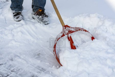 Foto de Hombre limpiando nieve con pala en el día de invierno, de cerca. Servicio de limpieza de la ciudad nieve invierno con pala después de tormenta de nieve patio - Imagen libre de derechos