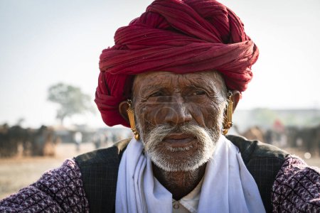 Téléchargez les photos : Pushkar, Rajasthan, Inde - 17 novembre 2018 : Portrait d'un vieil homme heureux non identifié à la foire aux bovins de Pushkar, Rajasthan, Inde - en image libre de droit