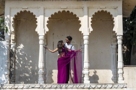 Téléchargez les photos : Udaipur, Inde - 24 nov. 2018 : Heureux jeune couple d'Indiens sur le fond d'un palais en pierre à Udaipur, Rajasthan, Inde - en image libre de droit
