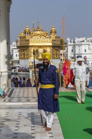 Foto de Amritsar, India - 29 de septiembre de 2014: guardia de seguridad sij con una lanza cerca del Templo Dorado en Amritsar, Punjab, India. Los peregrinos sij viajan desde toda la India para orar en este lugar sagrado. Amritsar, India - Imagen libre de derechos