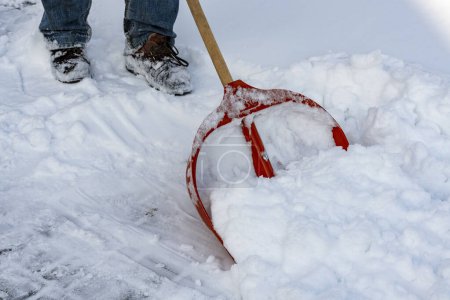 Téléchargez les photos : Homme nettoyer la neige avec une pelle dans la journée d'hiver, fermer. Service municipal nettoyage neige hiver avec pelle après neige tempête cour - en image libre de droit