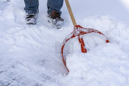 Foto de Hombre limpiando nieve con pala en el día de invierno, de cerca. Servicio de limpieza de la ciudad nieve invierno con pala después de tormenta de nieve patio - Imagen libre de derechos