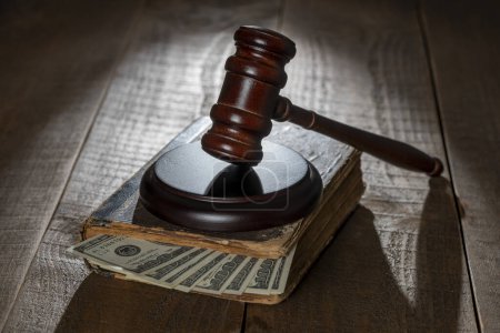 Photo for Wooden judge gavel, soundboard, old book with dollars on the background of a wooden table, close up - Royalty Free Image