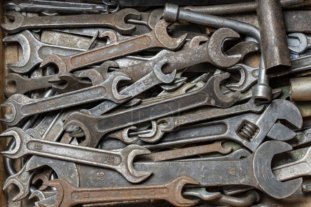 Téléchargez les photos : Boîte à outils en bois d'outils à main avec clés anciennes et sales, rouillées, clés à bague et autres bricolages pour bricolage, gros plan, vue de dessus - en image libre de droit