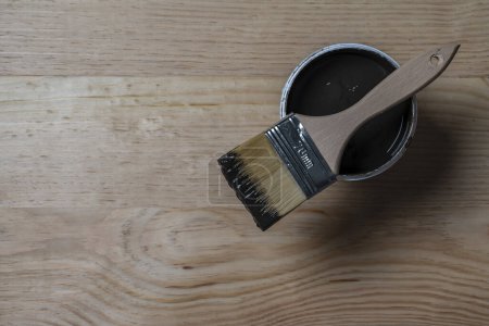 Photo for Top view on paint brush on the opened can on the wooden table background or floor painting and renovation repairing concept, copy space - Royalty Free Image