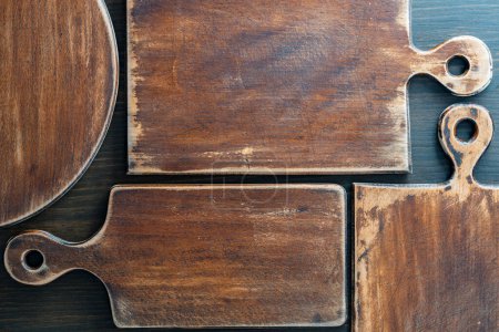 Foto de Tres viejas tablas de corte retro de varias formas sobre fondo de madera, de cerca - Imagen libre de derechos