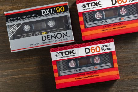 Photo for Kyiv, Ukraine - March 04, 2024 : TDK D 60 and Denon DX1 90, old vintage audio cassettes on wooden background. Retro analog hi-fi music tape, close up - Royalty Free Image