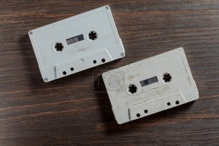 Téléchargez les photos : Deux vieilles cassettes audio vintage sur fond bois. Ruban rétro analogique hi-fi, gros plan, vue de dessus - en image libre de droit