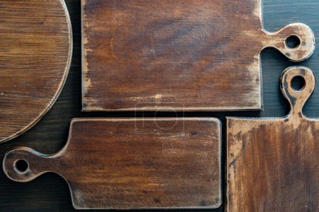 Foto de Tres viejas tablas de corte retro de varias formas sobre fondo de madera, de cerca - Imagen libre de derechos