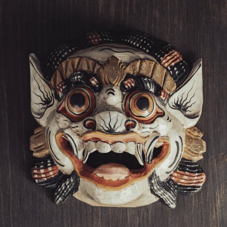 Asiatische rituelle Maske auf einem hölzernen Wandhintergrund. Nahaufnahme