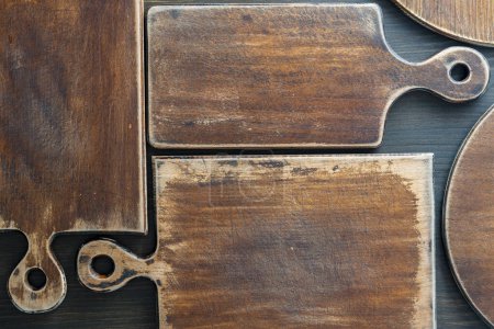 Photo for Three old retro cutting boards of various shapes on wooden background, close up - Royalty Free Image