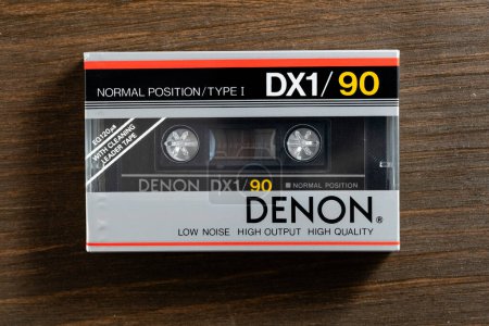 Photo for Kyiv, Ukraine - March 04, 2024 : Denon DX1 90, old vintage audio cassette on wooden background. Retro analog hi-fi music tape, close up - Royalty Free Image