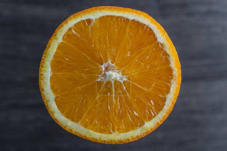 Photo for Close up of sliced ripe orange, macro. Yellow fresh orange surface on wooden background. Top view - Royalty Free Image