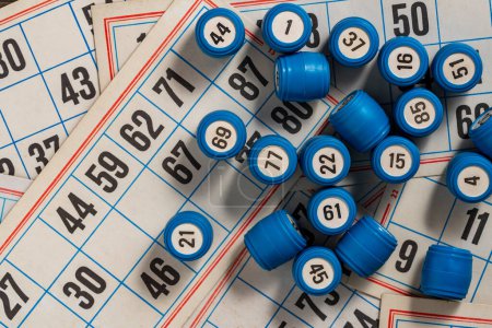 Photo for Tabletop old lotto game with cards and blue barrels on table, close up, top view - Royalty Free Image