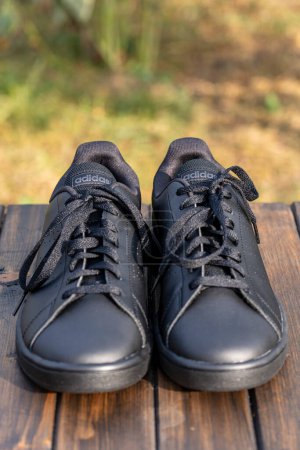 Téléchargez les photos : Kiev, Ukraine - octobre 05, 2023 : Belle nouvelle Adidas pleine chaussures noires sur la table en bois, gros plan - en image libre de droit
