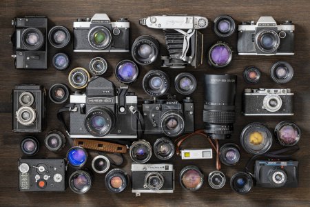Photo for Kyiv, Ukraine - October 27, 2023 : various vintage photo cameras , 35mm film, and old lenses made in USSR, close up, top view - Royalty Free Image