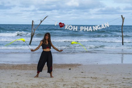 Téléchargez les photos : Koh Phangan, Thaïlande - 07 février 2022 : Fille pratiquer un poi pour danser spectacles avant la fête de la pleine lune sur la plage Haad Rin à l'île tropicale Koh Phangan, Thaïlande - en image libre de droit