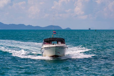 Téléchargez les photos : Koh Phangan, Thaïlande - 22 février 2022 : Bateau à moteur avec drapeau thaïlandais se déplace rapidement à travers les vagues bleues sur la mer ouverte, laissant derrière lui des éclaboussures de mousse blanche. Excursions en bateau à moteur - en image libre de droit