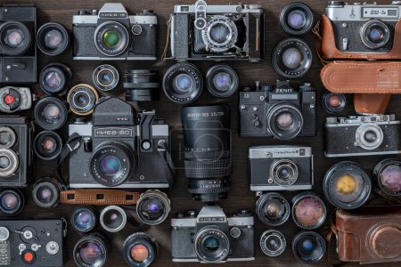 Foto de Kiev, Ucrania - 27 de octubre de 2023: varias cámaras de fotos vintage, película de 35 mm y lentes antiguas hechas en la URSS, de cerca, vista superior - Imagen libre de derechos