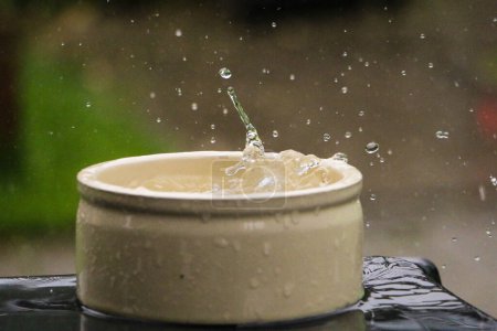 Téléchargez les photos : Rain is falling in a small white barrel full of water in the garden - en image libre de droit
