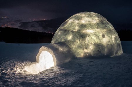 Téléchargez les photos : Paysage hivernal fantastique avec igloo lumineux en hiver montagnes des Carpates la nuit - en image libre de droit